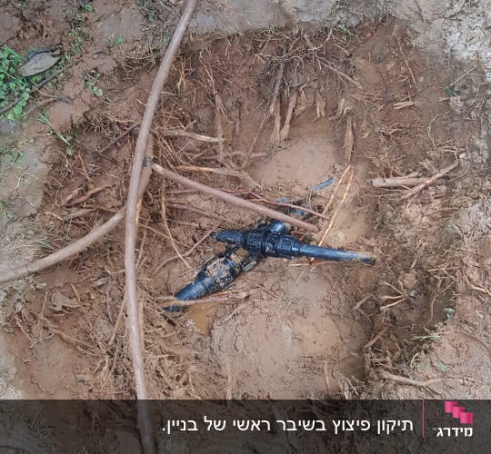 צינור שבור באדמה עם מים ובוץ